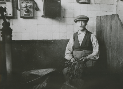 874826 Portret van sigarenmaker Jo 'de Rooie' van Hussen in de fabriek van de Koninklijke Nederlandsche Tabaks- en ...